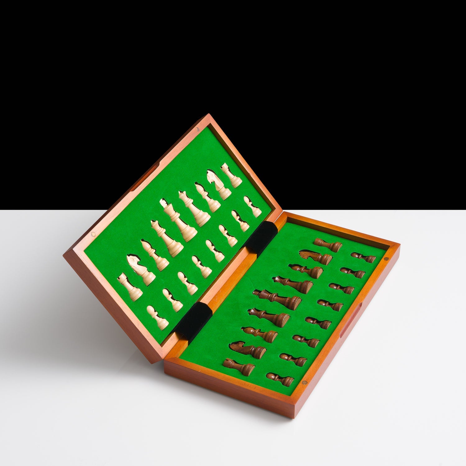 Chess pieces in an open wooden box with green felt interior