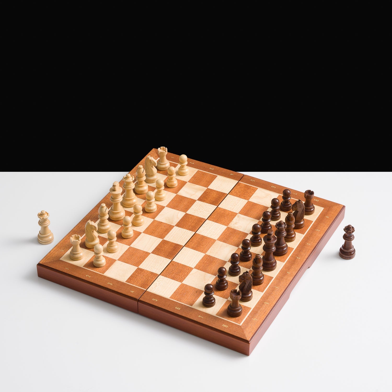Wooden chessboard with pieces on a white background